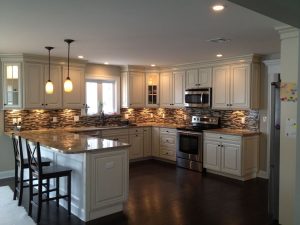 Kitchen with white cabinets, granite countertops, tile backsplash