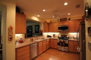 Kitchen with wood cabinets, quartz counter tops, wood floor, recess lights